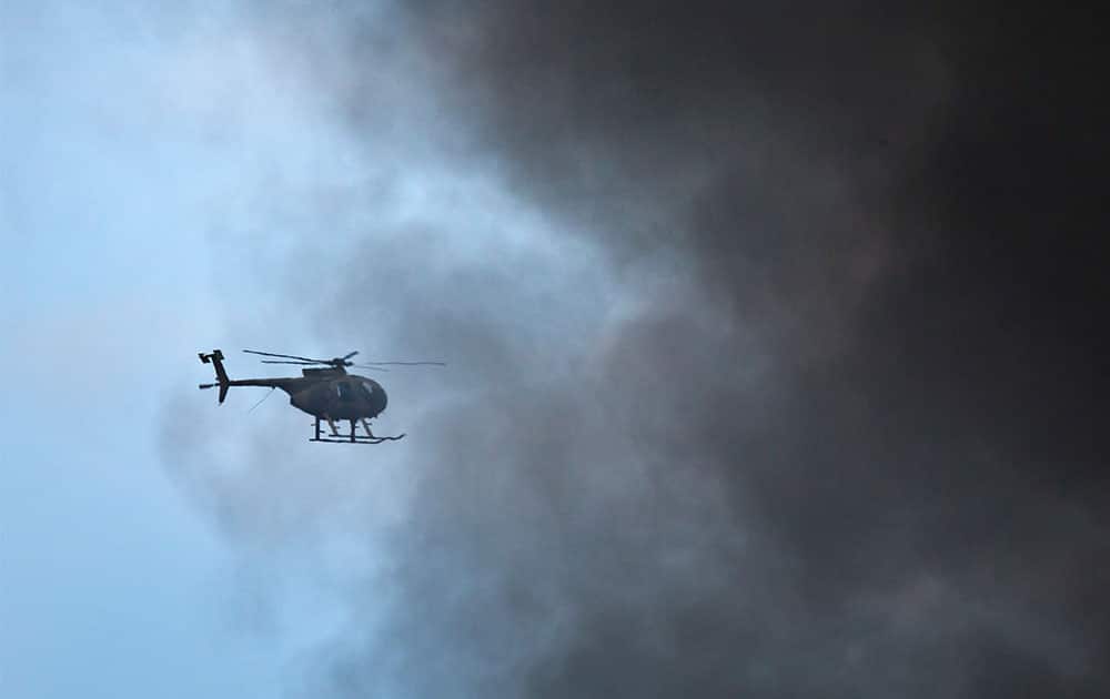A Kenya Army helicopter flies behind a plume of black smoke billowing from the Westgate Mall, following large explosions and heavy gunfire, in Nairobi.