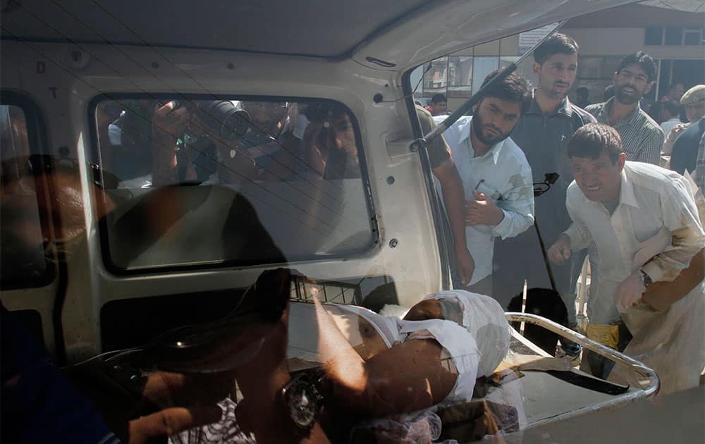 Kashmiri people watch an Indian paramilitary soldier injured in a rebel attack, lying on a stretcher inside an ambulance in Srinagar.