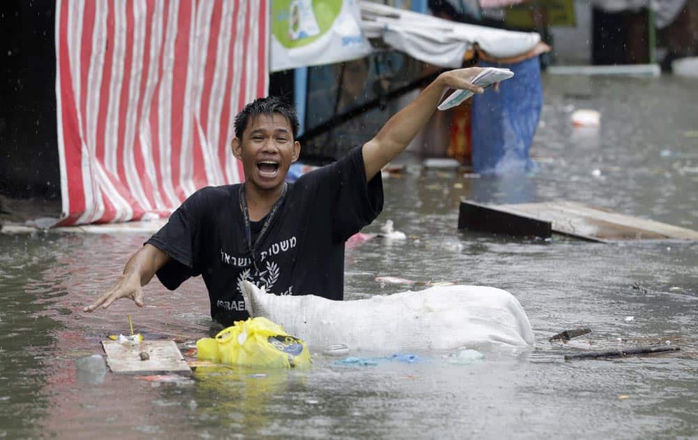A resident gestures as he wades through a flooded street at suburban Quezon city, northeast of Manila, following heavy rains brought about by Typhoon Usagi.