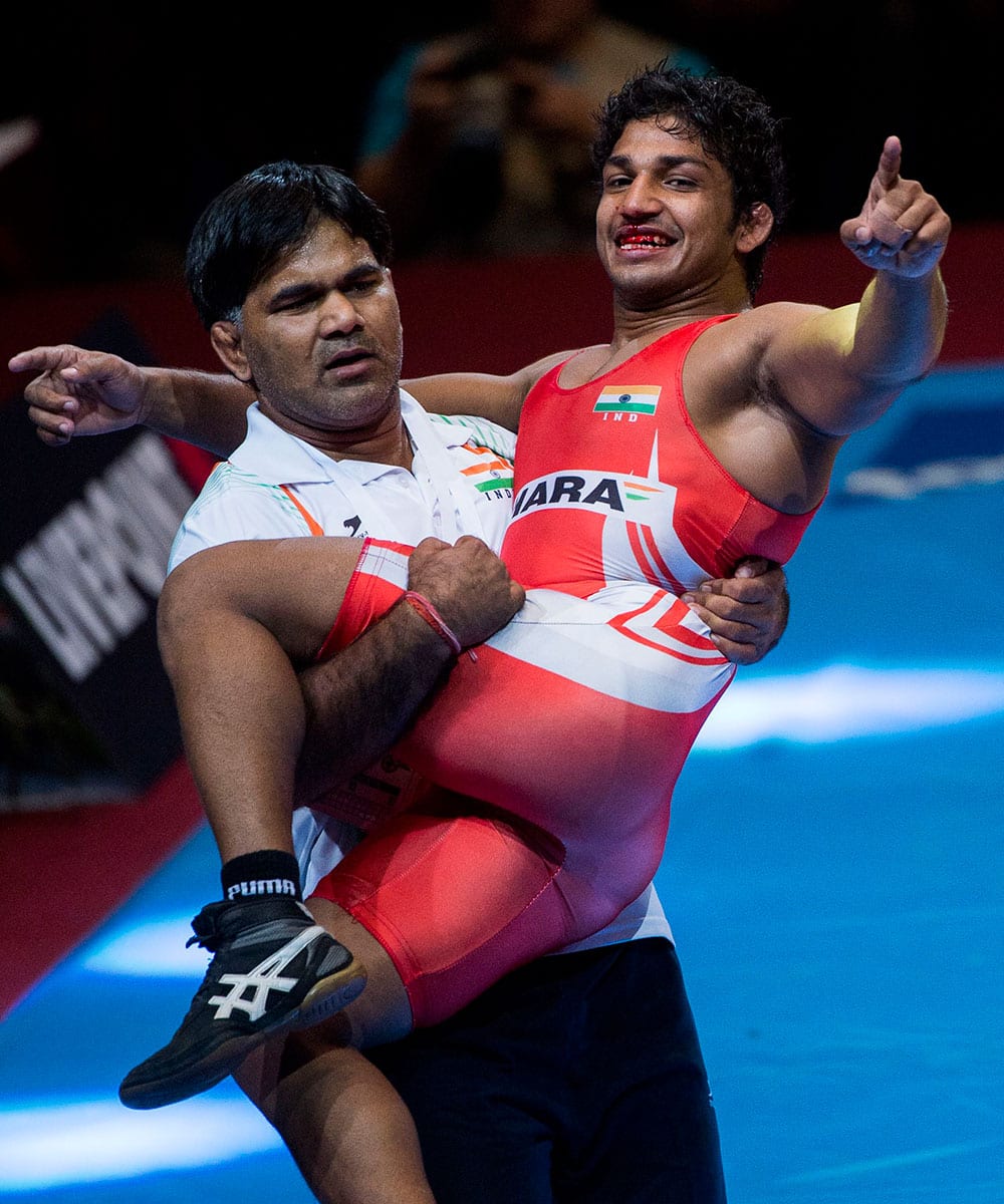 Tulsi Yadan Sandeep, right, of India celebrates with a team official after he defeated Aleksandar Maksimovic of Serbia and won one of the bronze medals of men’s Greco-Roman 66kg category of Wrestling World Championships in Papp Laszlo Budapest Sportsarena.