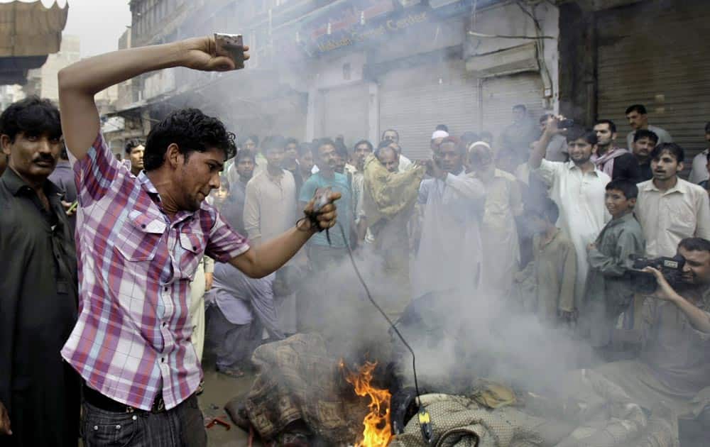 Pakistani Christians burn materials during a protest against the suicide attack on a church in Peshawar.