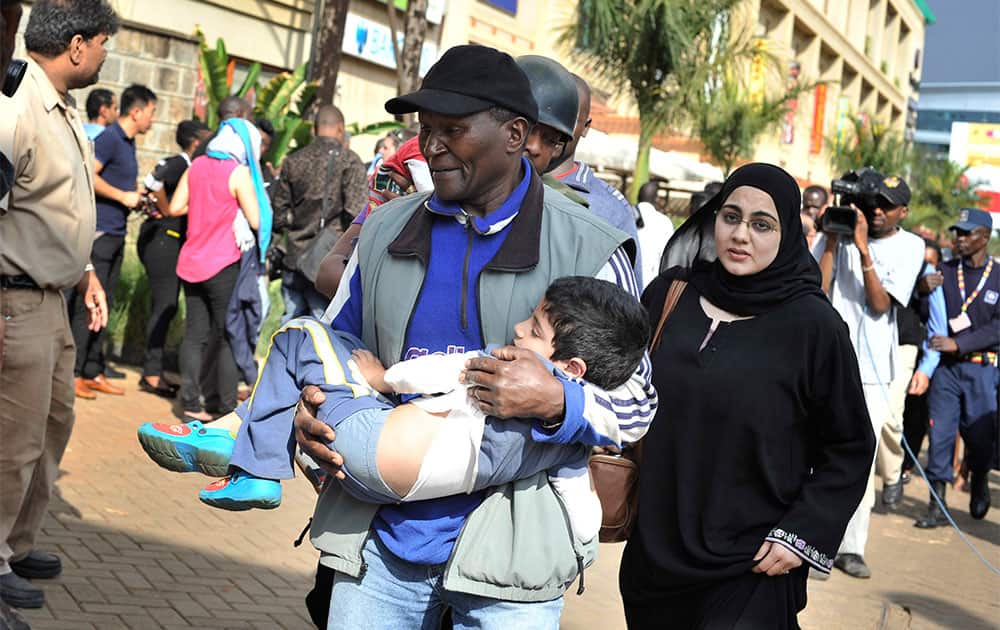 A rescue worker helps a child outside the Westgate Mall in Nairobi, Kenya, after gunmen threw grenades and opened fire during an attack that left multiple dead and dozens wounded.