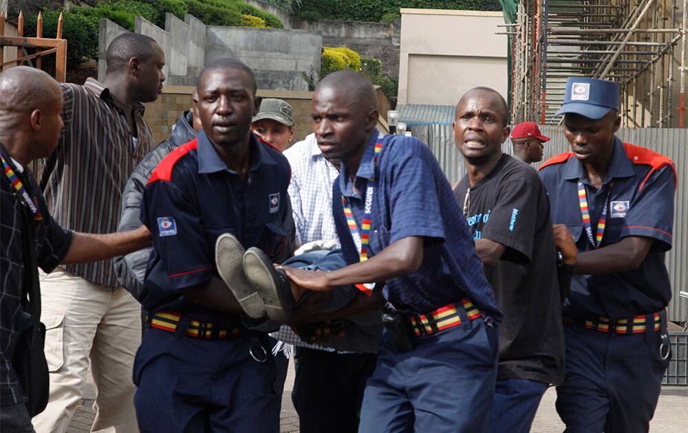 Security helps a wounded woman outside the Westgate Mall in Nairobi, Kenya, after gunmen threw grenades and opened fire during an attack that left multiple dead and dozens wounded.