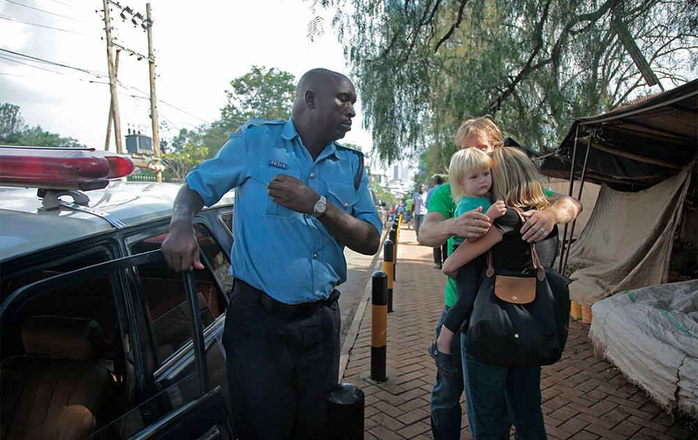 Lyndsay, centre right, embraces daughter Julia and husband Nick, partially seen, in a reunion that came after the couple had been separated for three hours inside a mall under attack by al-Shabab terrorists in Nairobi, Kenya.