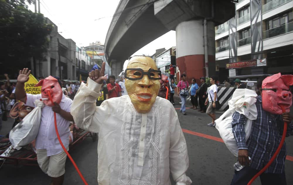 A Filipino protester wears a mask of Philippine President Benigno Aquino III as they mark the 41st anniversary of declaration of Martial Law during a rally at the historic Mendiola bridge, just outside the Malacanang presidential palace in Manila, Philippines .