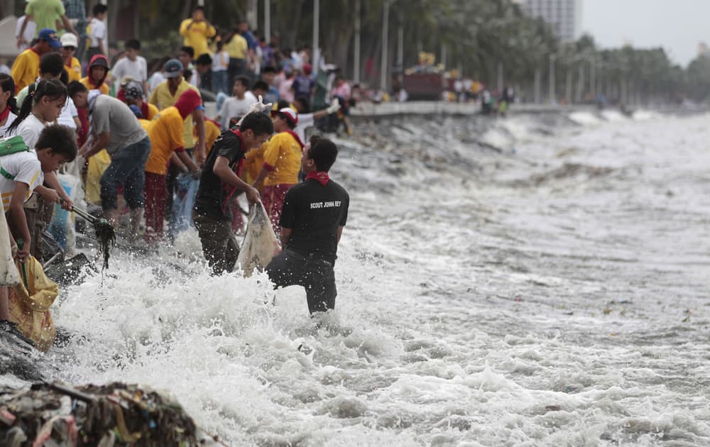 Strong waves hit students and volunteers joining the international coastal clean-up day at the polluted Manila bay, Philippines.
