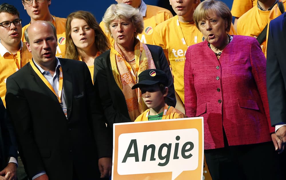 German Chancellor and chairwoman of the German Christian Democratic party (CDU), Angela Merkel and party supporters sing the national anthem during an election campaign event in Berlin, Germany.