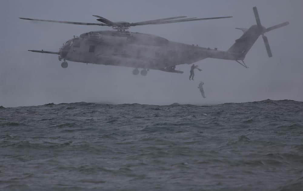 Filipino Marines and US Marines jump from a CH-53 Super Stallion helicopter during a joint military exercise called Philippines-US Amphibious Landing Exercise in Ternate, Philippines.