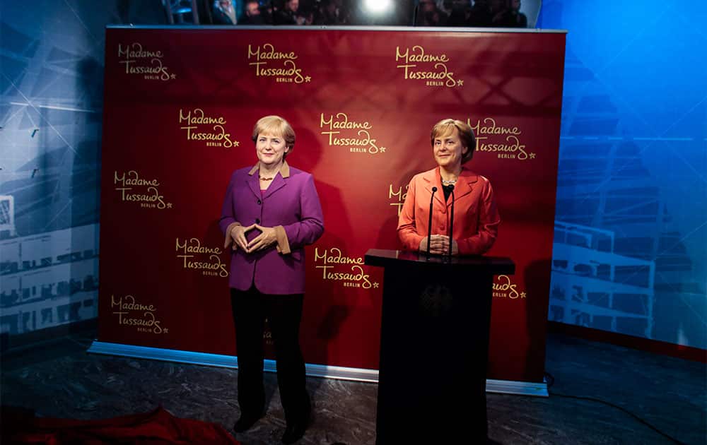 A new wax figure of German Chancellor Angela Merkel, left, is presented to the media next to a wax figure from 2005, right, at Madame Tussauds in Berlin, Germany.