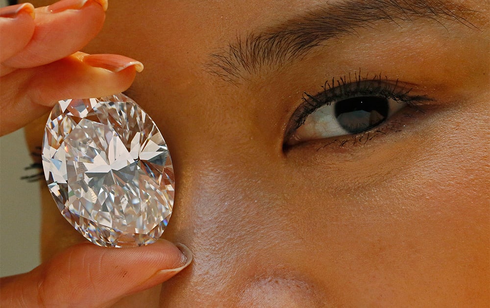A 118.28-carat white diamond is displayed by a model at a press preview at Sotheby`s auction house in Hong Kong.