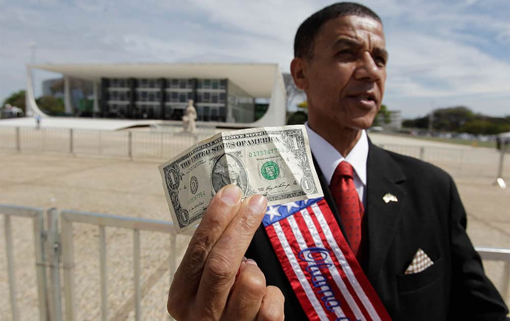 Jose Maria, a demonstrator imitating President Barack Obama, holds up a US dollar bill outside the Supreme Court in Brasilia, Brazil.