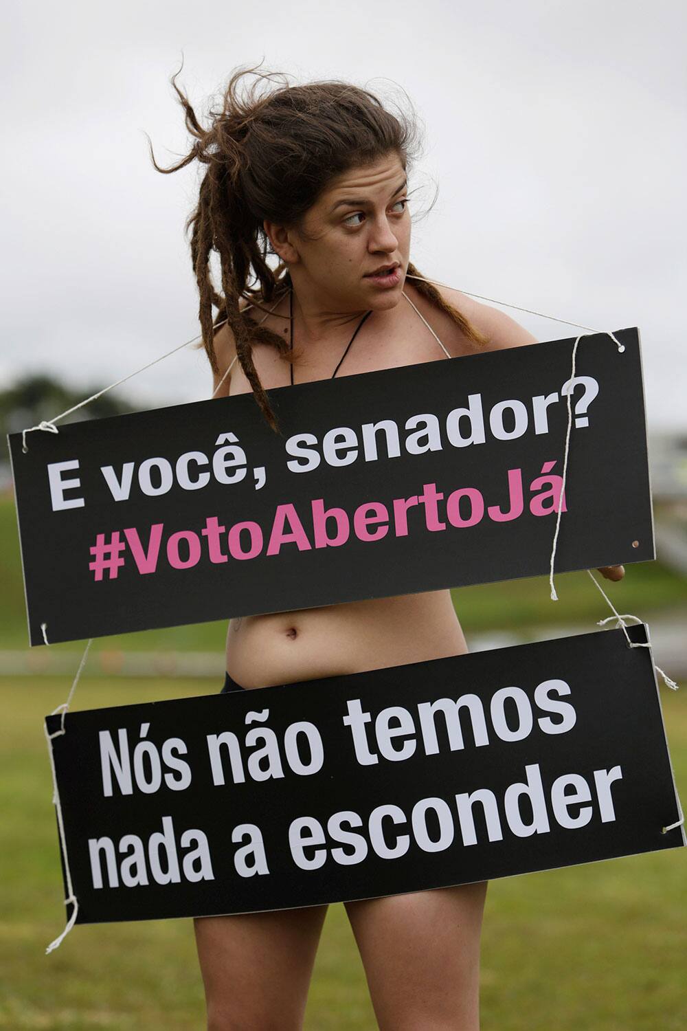 A demonstrator from the Avaaz organization wears posters that read in Portuguese