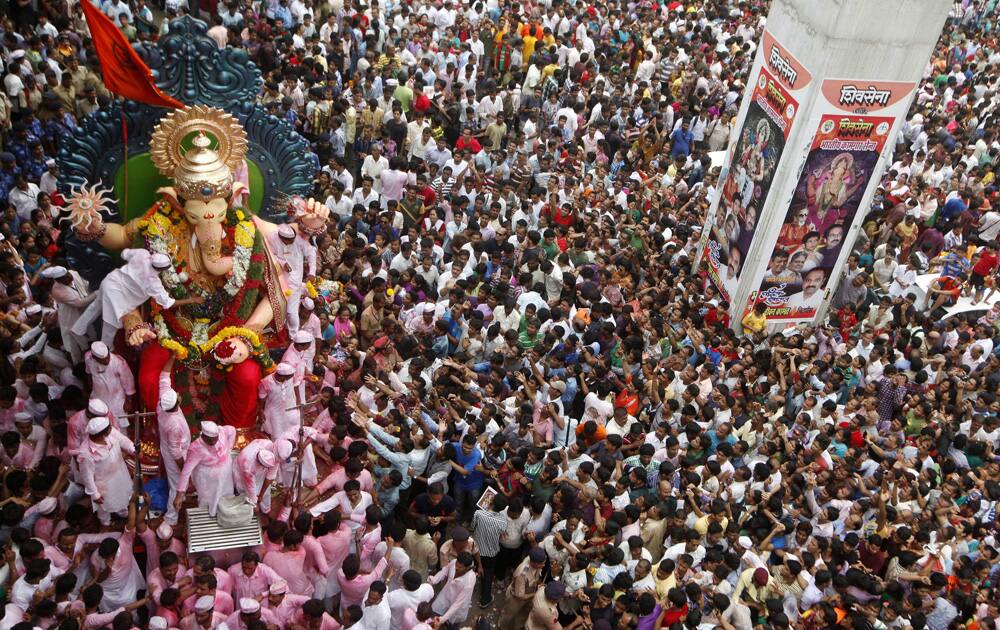 Devotees take an idol of Hindu god Ganesha through a street for immersion in the Arabian Sea in Mumbai.