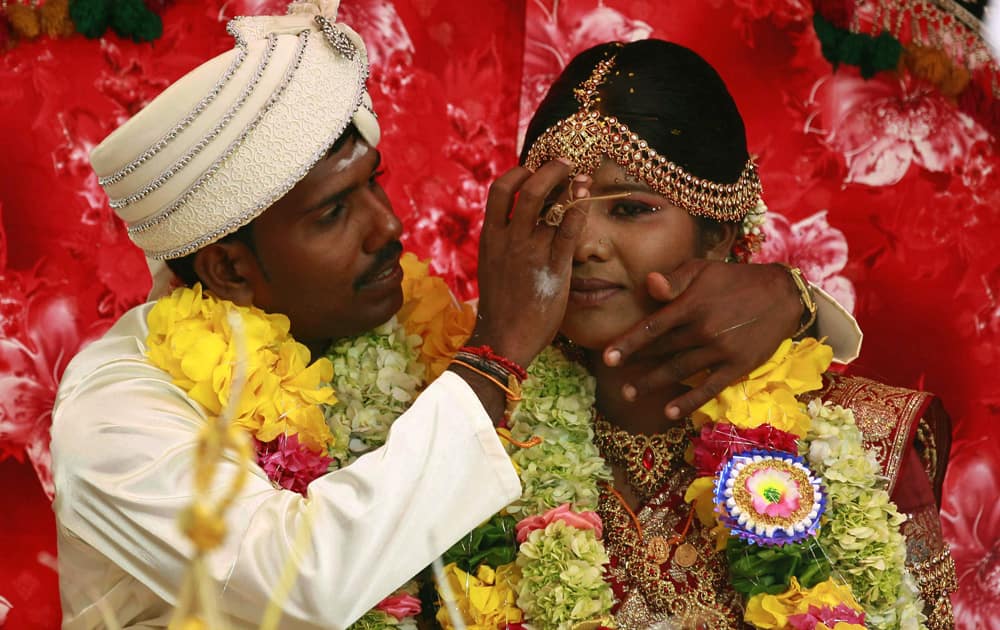 Murugaiah Shashikumar, a rehabilitated former Tamil Tiger rebel fighter applies vermillion on the forehead of his bride Premaratnam Suganthini, another former rebel, during their wedding ceremony in Vishwamadu, northern Sri Lanka.