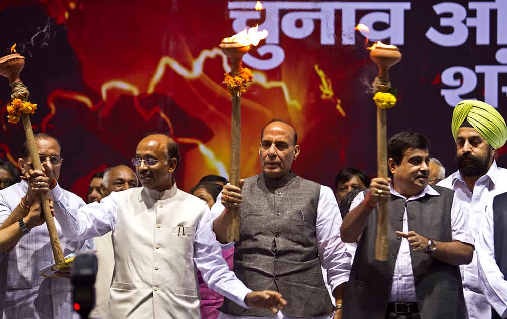 Bharatiya Janata Party (BJP) president Rajnath Singh along with party leaders Vijay Goel and Nitin Gadkari hold torches during an election campaign rally in New Delhi, India.