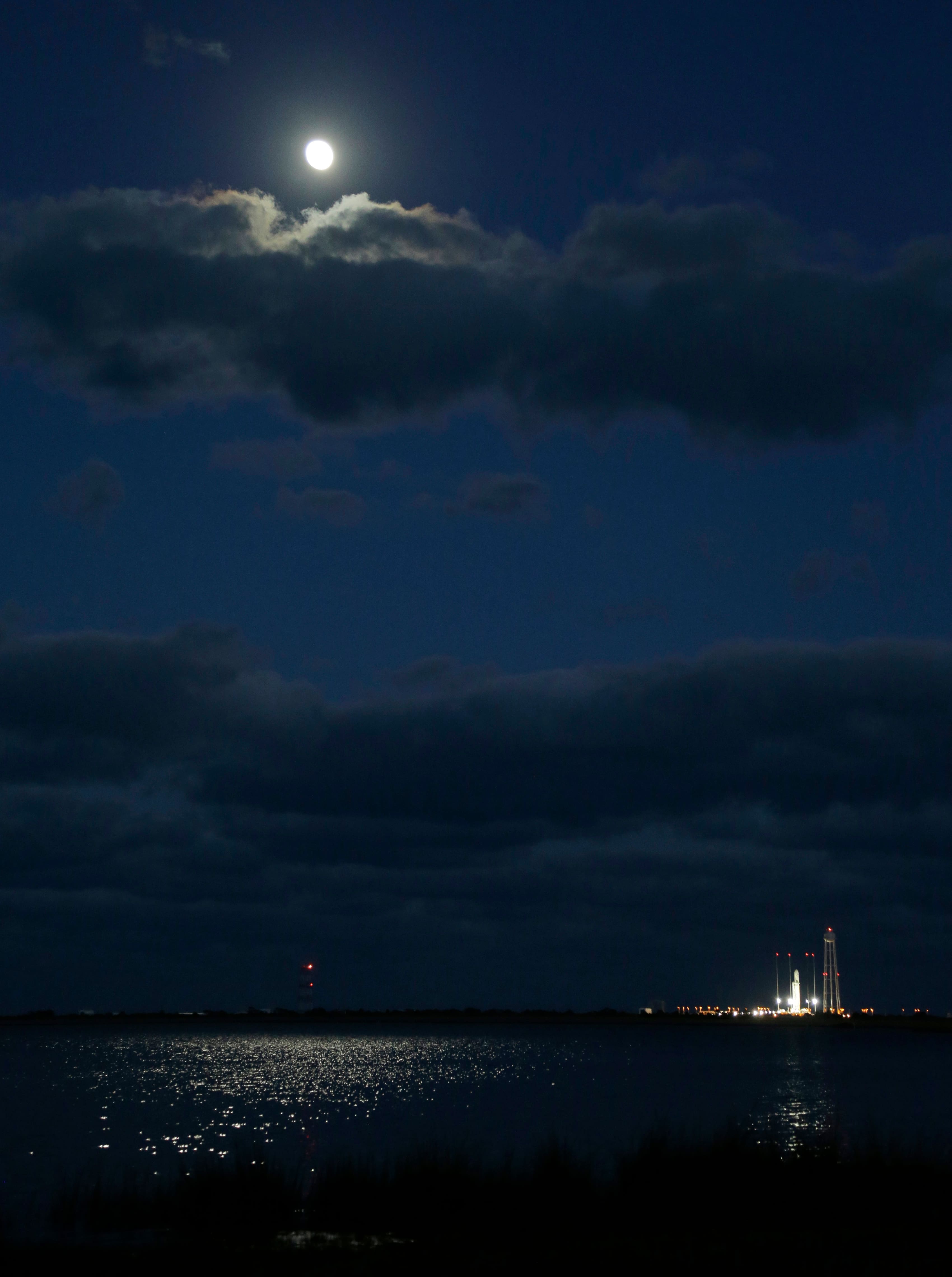 The moon rises over Orbital Sciences Corp. Antares rocket as it is readied on the launchpad at the NASA Wallops Island test flight facility in Wallops Island, Va.