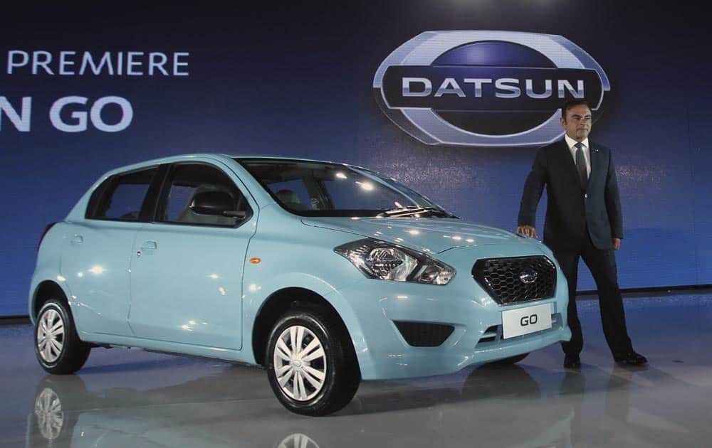 Nissan Motor Co. President and CEO Carlos Ghosn poses for photographers with a Datsun GO during its unveiling for Indonesian market in Jakarta.