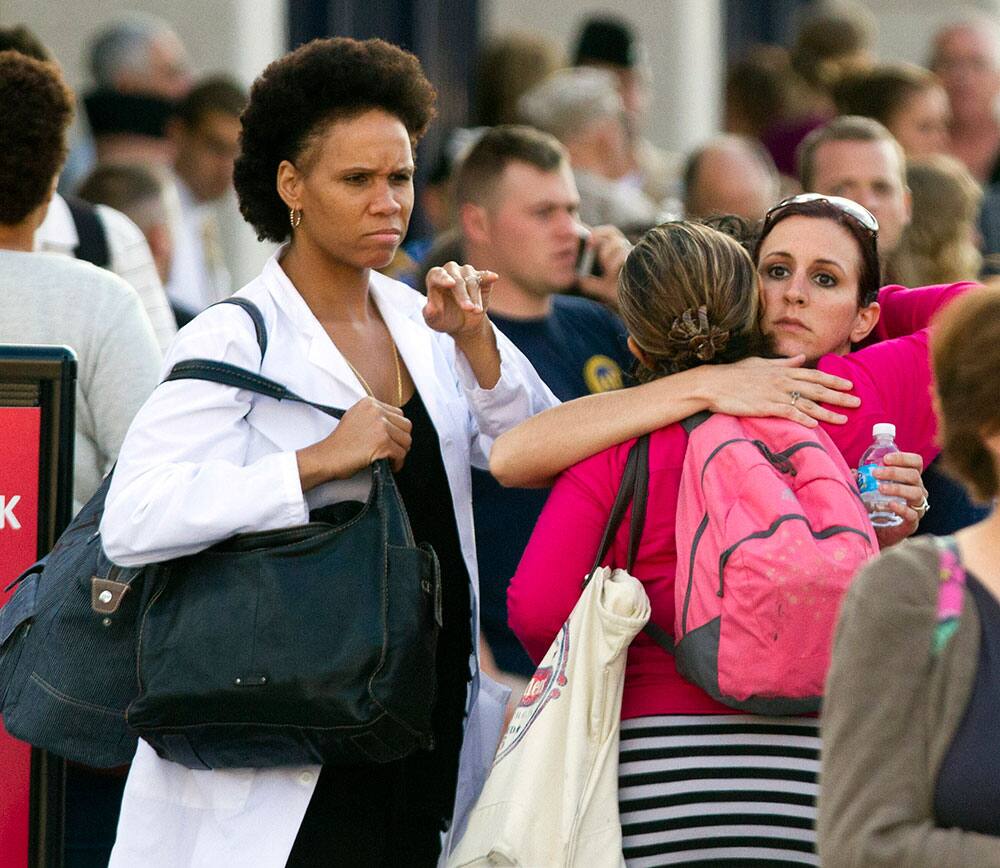 Family and friends greet staff of the Naval Sea Systems Command headquarters after they were bused from the Washington Navy Yard to Nationals Park, in Washington.