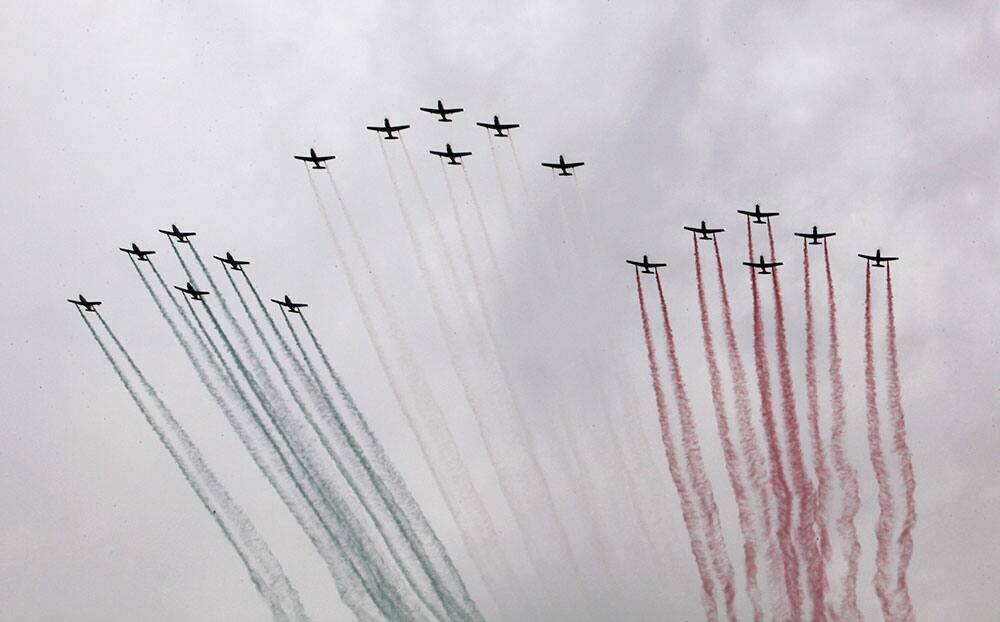 Mexican Air Force aircraft release smoke with the colors of the Mexican flag as they fly over during the Independence Day military parade in the Zocalo, in Mexico City.