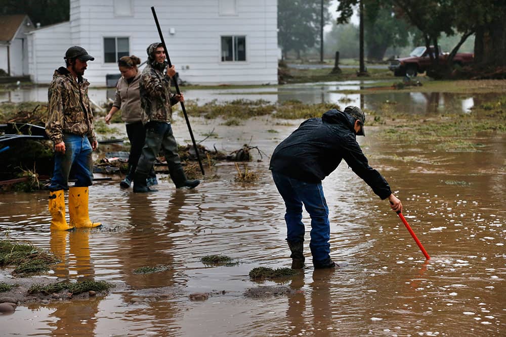 Local residents, left to right, Tyler Sadar, Miranda Woodard, Joey Schendel, and Levi Wolfe help salvage and clean property in an area inundated after days of flooding, in Hygiene, Colo.