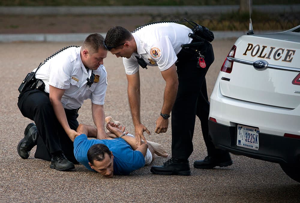 A man is taken into custody by uniformed Secret Service Police on Pennsylvania Avenue outside the White House in Washington.