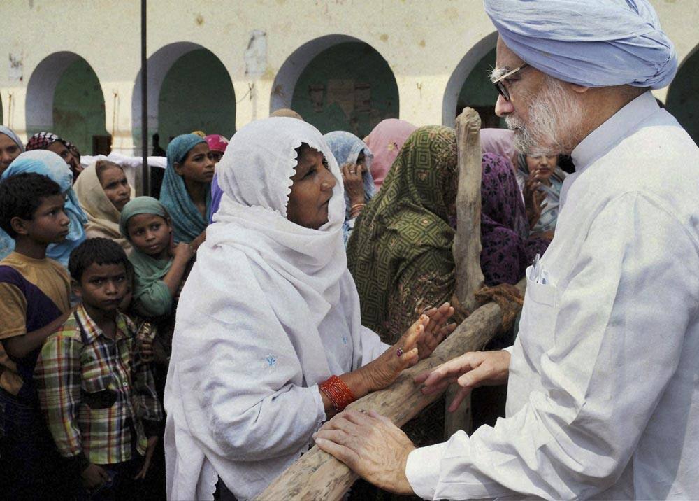 Prime Minister Manmohan Singh, interacts with a riot affected woman at a relief camp in Muzaffarnagar, about 125 kilometers north of New Delhi.