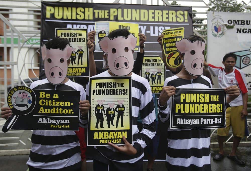 Filipino protesters wear pigs masks as they hold slogans during a rally outside the Office of the Ombudsman, or the anti-graft prosecutor in suburban Quezon city, north of Manila, Philippines.