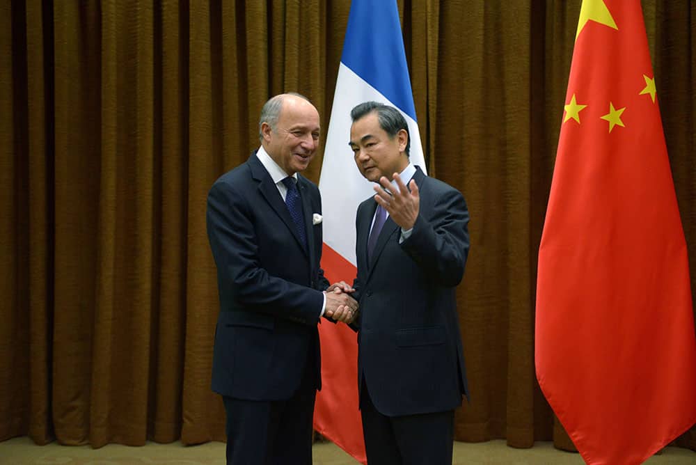 French Foreign Minister Laurent Fabius, left, shakes hands with his Chinese counterpart Wang Yi before their meeting at the Chinese Foreign Ministry in Beijing.