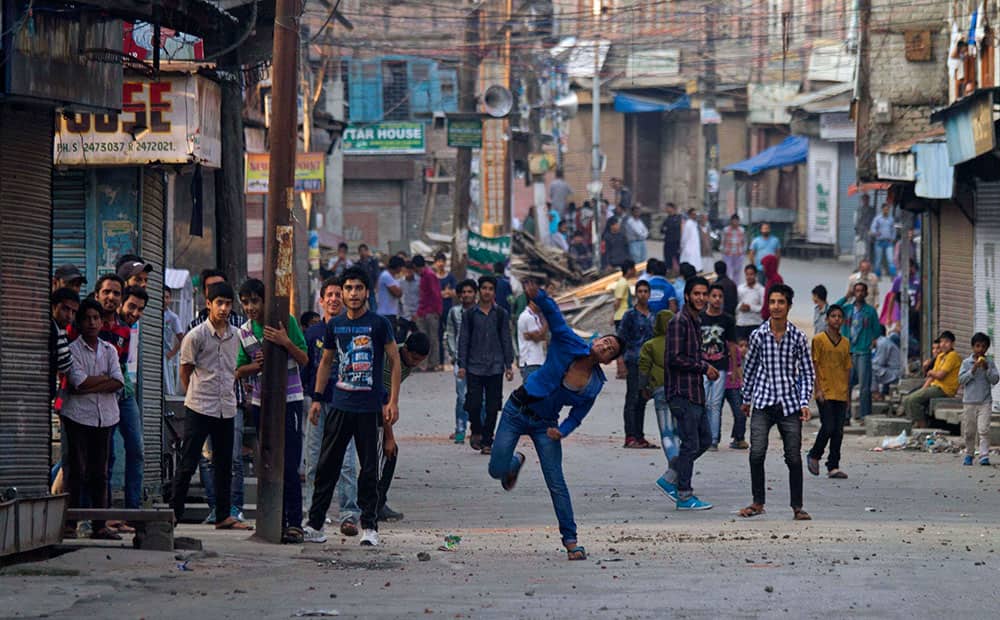 A Kashmiri protester throws stones at Indian paramilitary soldiers during a protest in Srinagar.