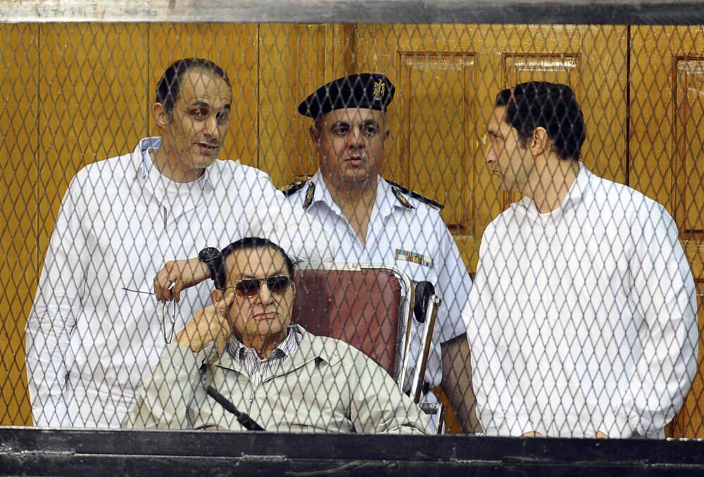 Former Egyptian President Hosni Mubarak and his two sons Gamal Mubarak, left, and Alaa Mubarak, right, attend a hearing in a courtroom at the Police Academy, Cairo, Egypt.