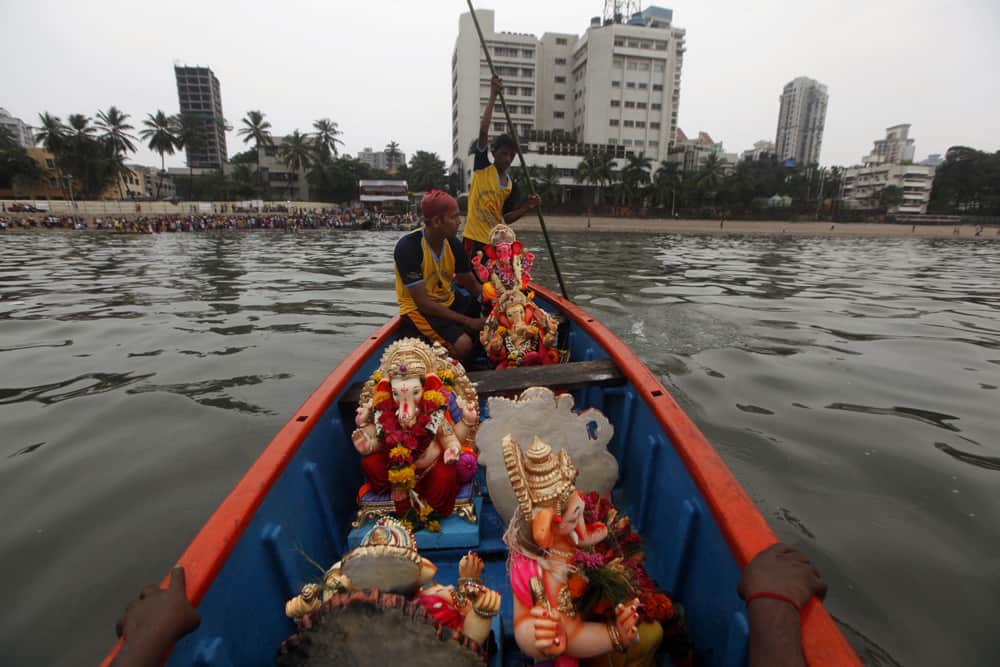 People carry idols of elephant-headed Hindu god Ganesha on a boat for immersion in the Arabian Sea during the Ganesh Chaturthi festival celebrations in Mumbai.