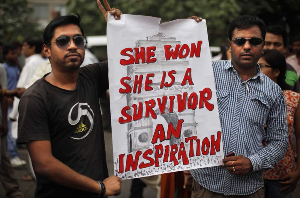 People hold a placard outside a court after a judge sentenced to death four men for the December rape and murder of a student on a moving New Delhi bus, in New Delhi.
