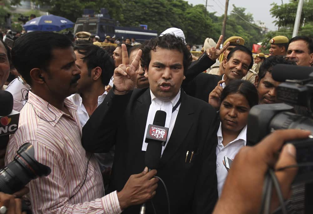 An unidentified lawyer from the prosecution side displays a victory sign as he speaks to journalists after a judge pronounced death sentence for all four men convicted in the rape and murder of a student on a moving New Delhi bus last year, in New Delhi.