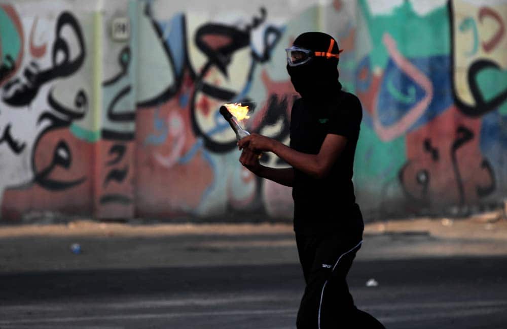 A Bahraini anti-government protester prepares to throw a petrol bomb during clashes with riot police, in Daih, Bahrain.