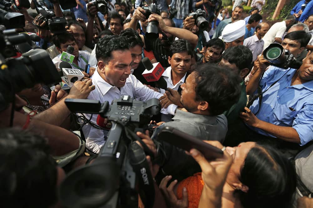 Defense lawyer A.P. Singh reacts physically to a protester heckling him for defending a convict in the fatal gang rape of a young woman on a moving New Delhi bus last year, outside a court in New Delhi.