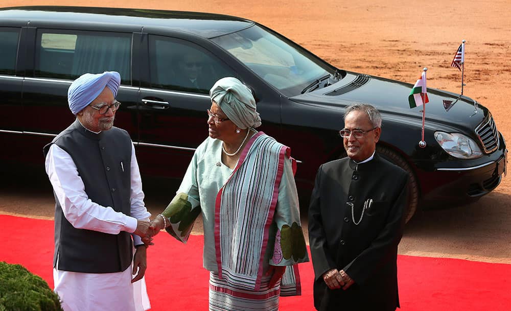 Prime Minister Manmohan Singh welcomes Liberian President Ellen Johnson Sirleaf, as President Pranab Mukherjee poses for the media during a ceremonial reception at the Indian presidential palace in New Delhi.