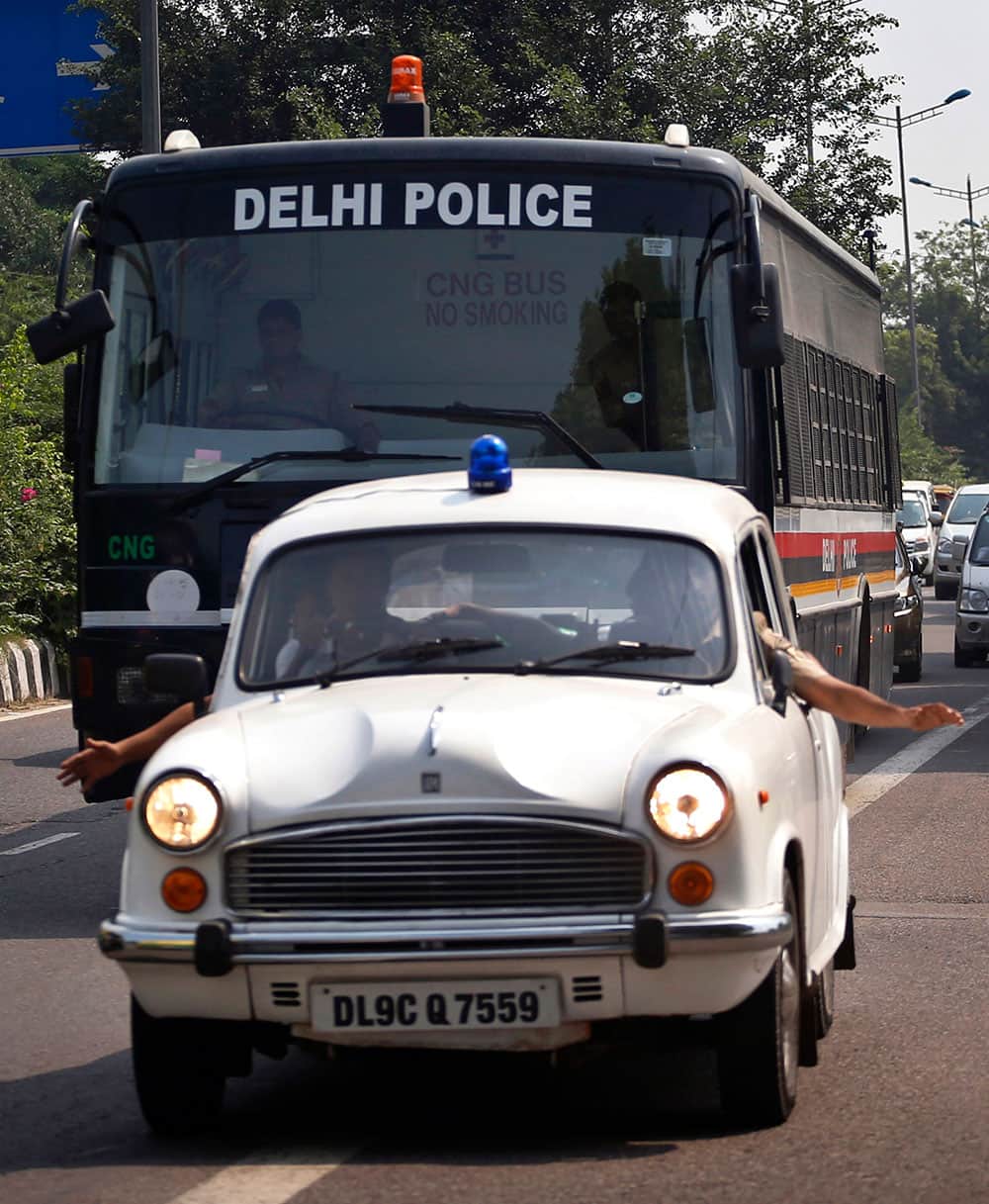 A police car clears the way for a van carrying four men convicted in the fatal gang rape of a young woman on a moving New Delhi bus last year on the way to a court complex to be sentenced, in New Delhi.