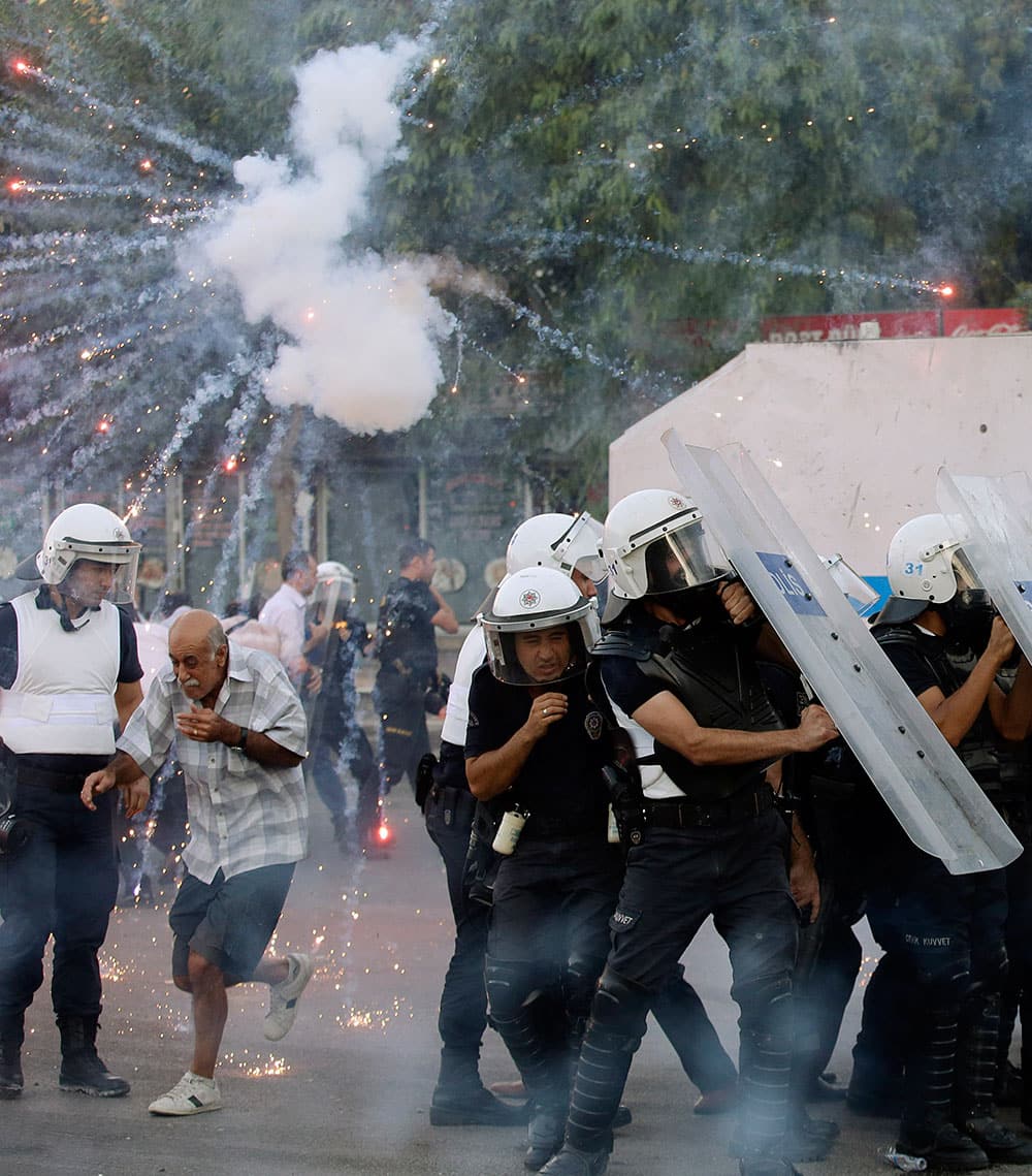 Turkish police officers shelter from fireworks fired by demonstrators during clashes which broke out to protest the death of Ahmet Atakan in Hatay, Turkey.