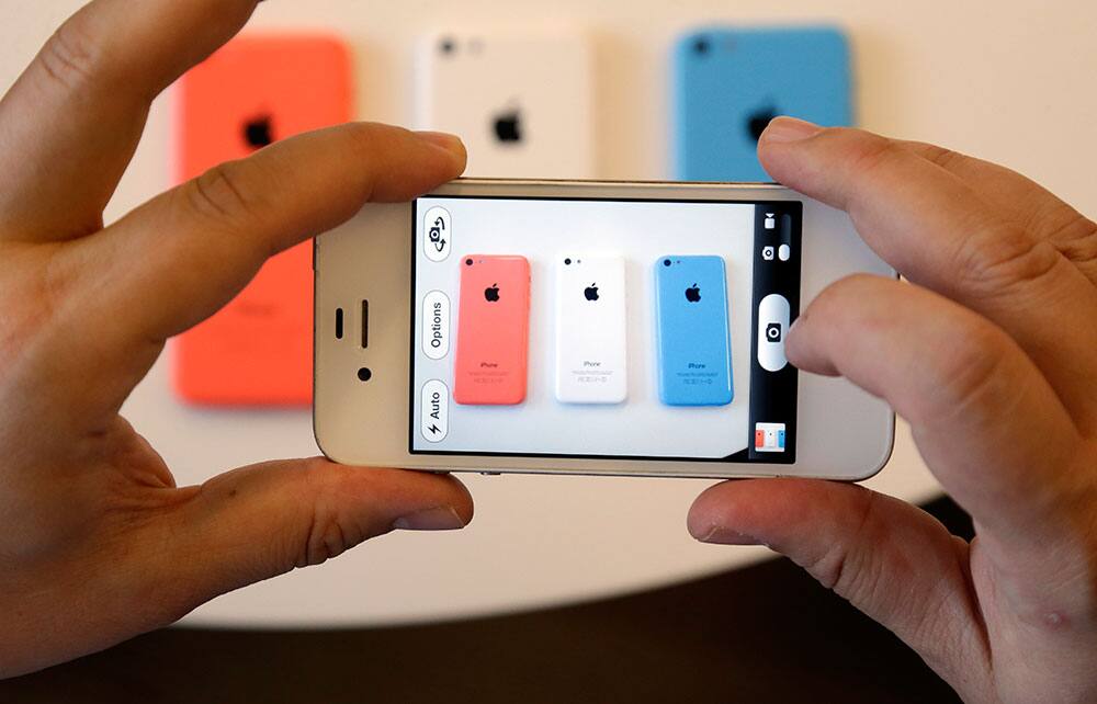 Members of the media review the new iPhone 5c during a new product announcement at Apple headquarters in Cupertino, Calif.