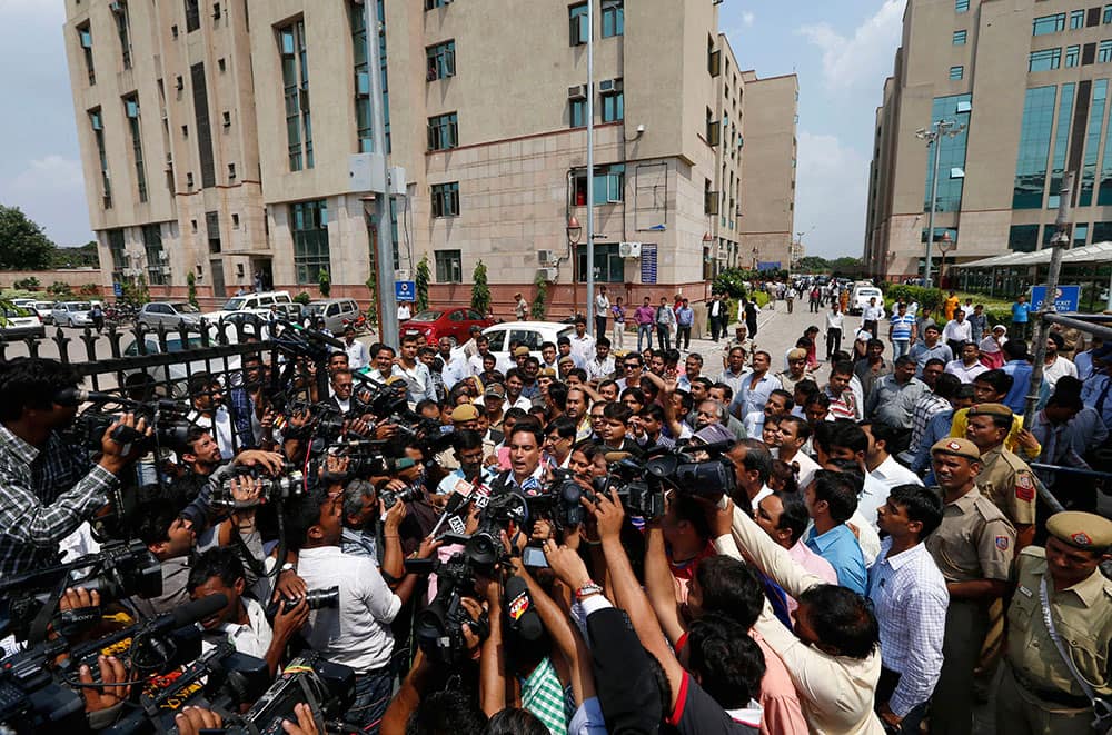 Defense lawyer A.P. Singh, center, speaks to journalists as he comes out after an Indian court convicted four men Tuesday in the fatal gang rape of a young woman on a moving New Delhi bus last year, in New Delhi, India.