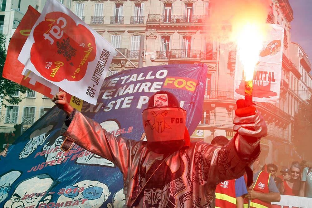 A steelworker burns a flare during a nationwide day of protest, with workers of the private sector and public services, in Marseille, southern France.