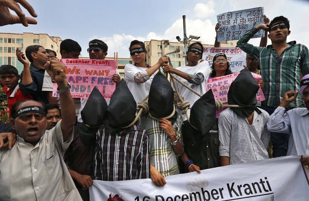 Protestors stage a mock hanging scene to demand death sentence for four men after a judge convicted them in the fatal gang rape of a young woman on a moving New Delhi bus last year, in New Delhi.