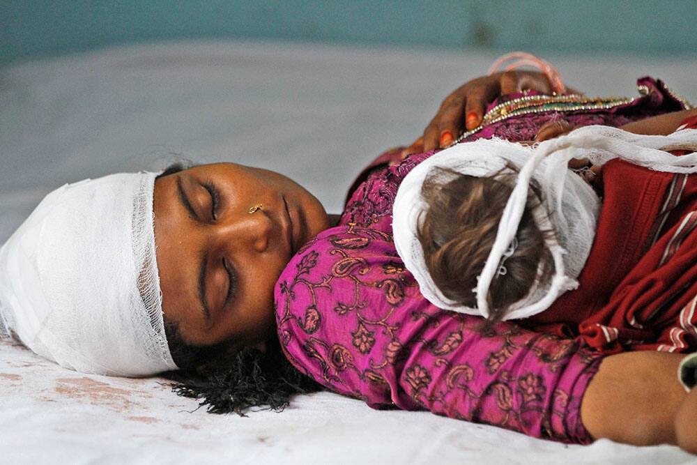Gulista, a 24-year-old woman, lies with her 8-month-old son Ayan for treatment at a district hospital after they were injured in communal clashes in Muzaffarnagar.