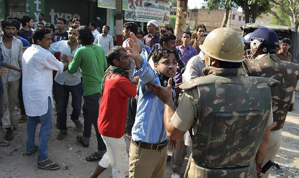 People argue with Indian policemen during curfew hours following riots and clashes between two communities in Muzaffarnagar, in the Indian state of Uttar Pradesh.