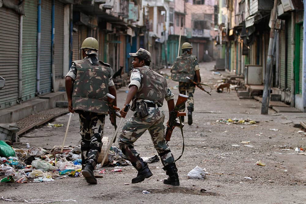 Security forces chase rioters, unseen, during an army-enforced curfew imposed following deadly clashes between Hindus and Muslims at Muzaffarnagar in Uttar Pradesh state.