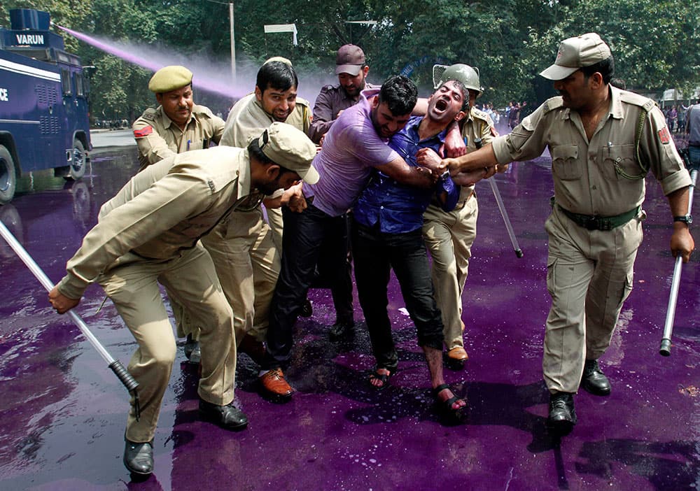Police use colored water cannon and detain Kashmiri government employees during a protest in Srinagar.