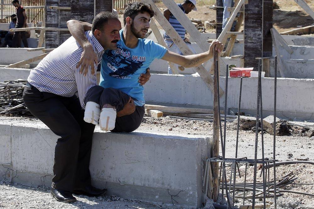 Mustafa Abu Bekir, 23, is carried by his relative after crossing the Turkish Cilvegozu gate border. Abu Bekir, said he was severely wounded by a bomb dropped from a Syrian Army warplane, while fighting with the Free Syrian Army a month ago in Idlib.