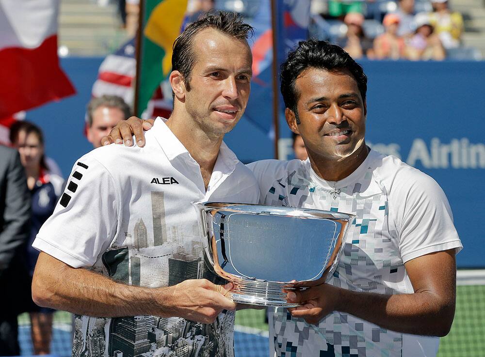 Radek Stepanek, of the Czech Republic, left, and Leander Paes, of India, hold the championship trophy after defeating Alexander Peya, of Austria, and Bruno Soares, of Brazil, in the men`s doubles final of the 2013 US Open tennis tournament.