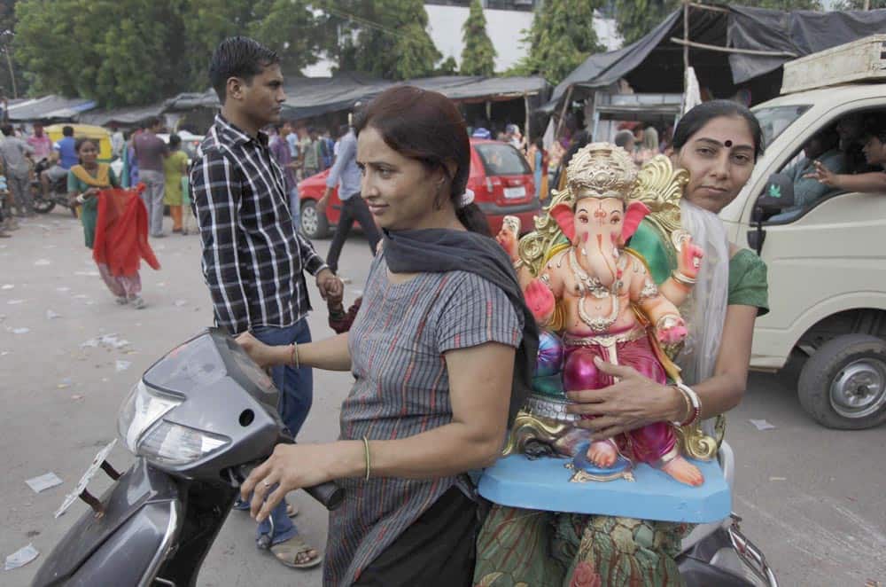 Women on a two wheeler carry idols of elephant headed Hindu god Ganesh on the eve of Ganesh Chaturthi festival in Ahmedabad. The ten day long festival ends with the immersion of idols in water bodies.
