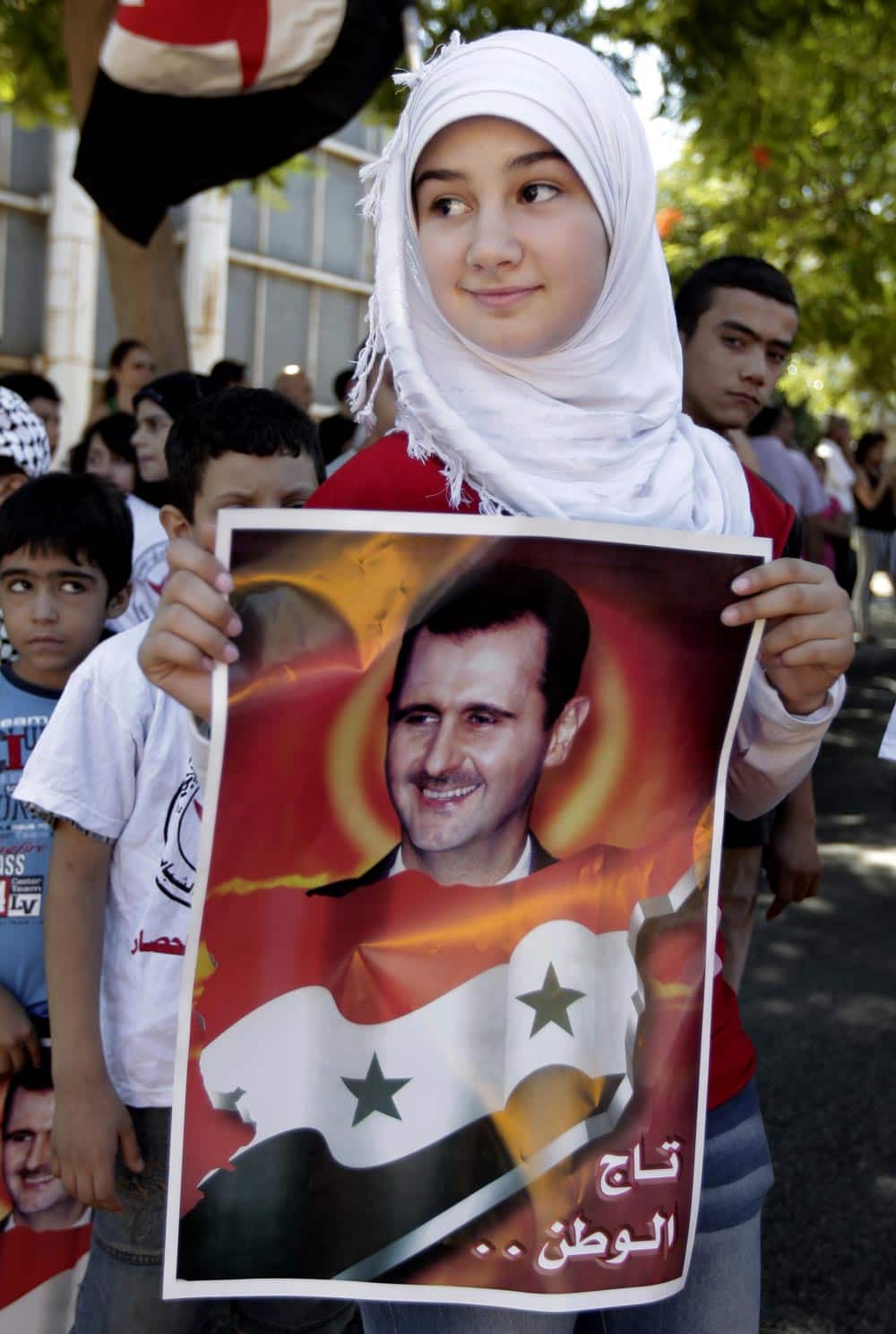A Lebanese girl holds a portrait of Syrian President Bashar Assad, during a demonstration against a possible military strike in Syria, in front of the United Nations headquarters, in Beirut, Lebanon.